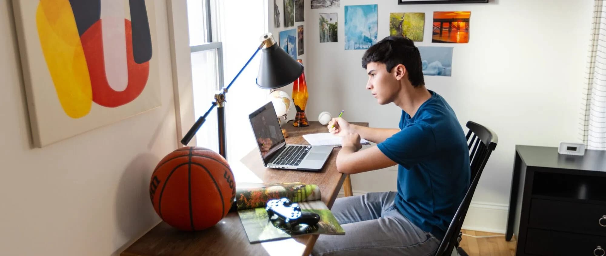 High school student studying at a desk with a laptop